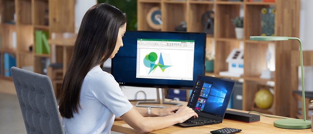 O persoană stând la un birou utilizând un computer