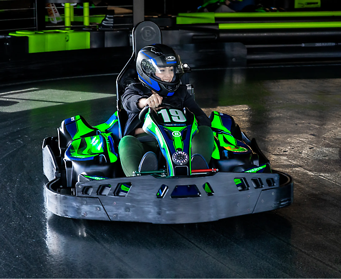 Een persoon die een helm draagt en een go-kart bestuurt.