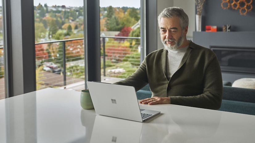 A person sitting at a kitchen counter using a laptop