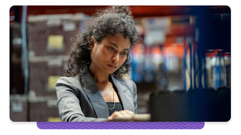 A woman wearing a blazer working at a computer