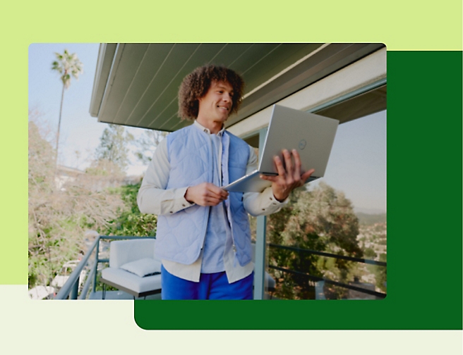 A person standing in the patio and using his laptop