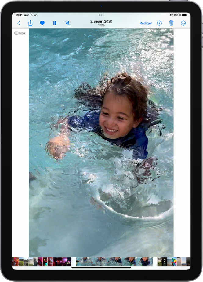 Videoavspilleren i Bilder-appen vises midt på skjermen, og det spilles av en video. Nederst på skjermen viser en bildevisning stillbilder fra venstre mot høyre, og en indikator viser hvilket bilde fra videoen som spilles på skjermen.