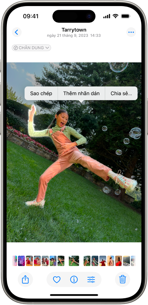 Ứng dụng Ảnh được mở với một ảnh về một người. Người được chọn và tùy chọn Thêm nhãn dán khả dụng trong menu bên trên.