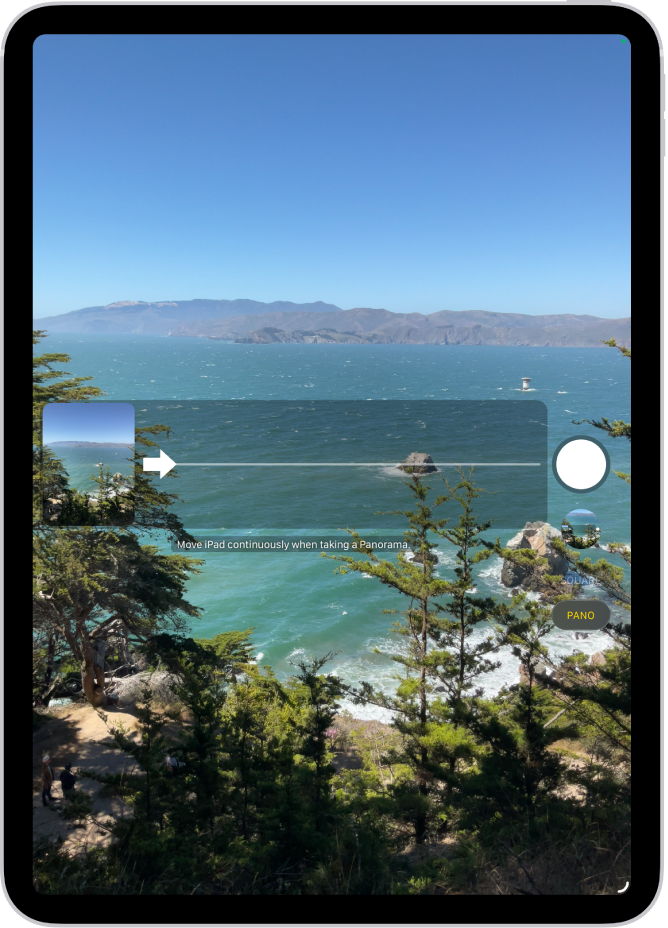कॅमेरा पॅनोरामा मोडमध्ये आहे. पॅनची दिशा दाखवण्यासाठी मध्यभागी डाव्या बाजूला, ॲरो उजवीकडे निर्देश करतो.
