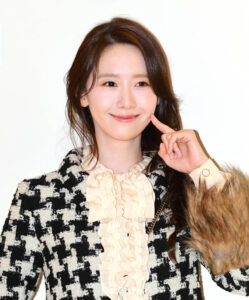Smiling woman in elegant black-and-white outfit.