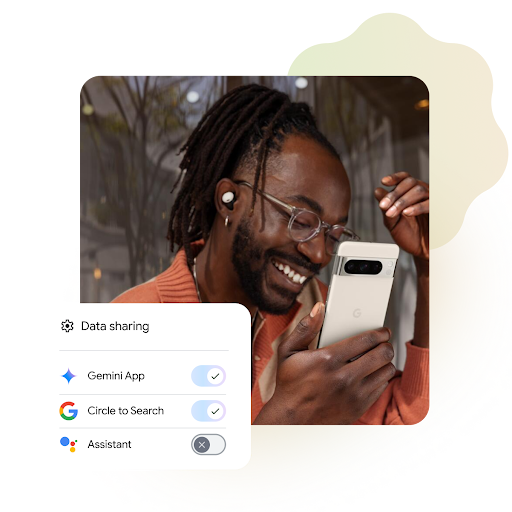 A man wearing glasses smiles while looking at his phone. A popup on the screen shows data-sharing settings, with toggles turned on for "Gemini App" and "Circle to Search," and turned off for "Assistant."