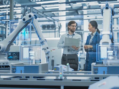 A man and woman at a electronics factory assembly line.