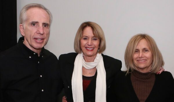Three people standing together for a photo.