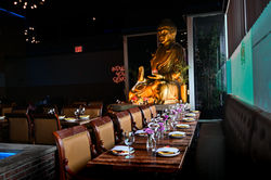 Dining table beside golden Buddha statue at Jade Eatery & Lounge in Long Island – serene prix-fixe s