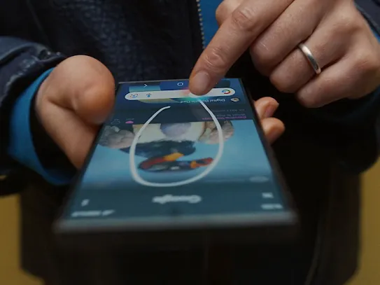 A close-up of someone’s hands circling an image on their phone, using the Circle to Search feature.